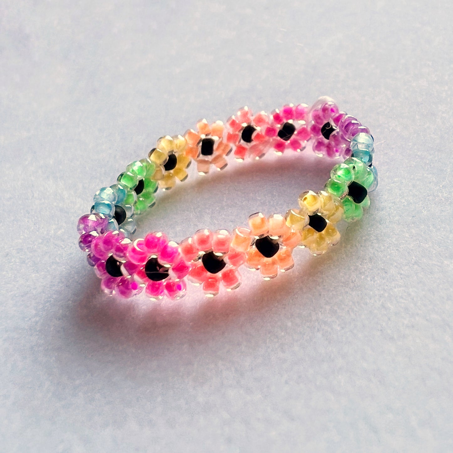Flower ring in rainbow luminous blacklight beads (mini bead size)